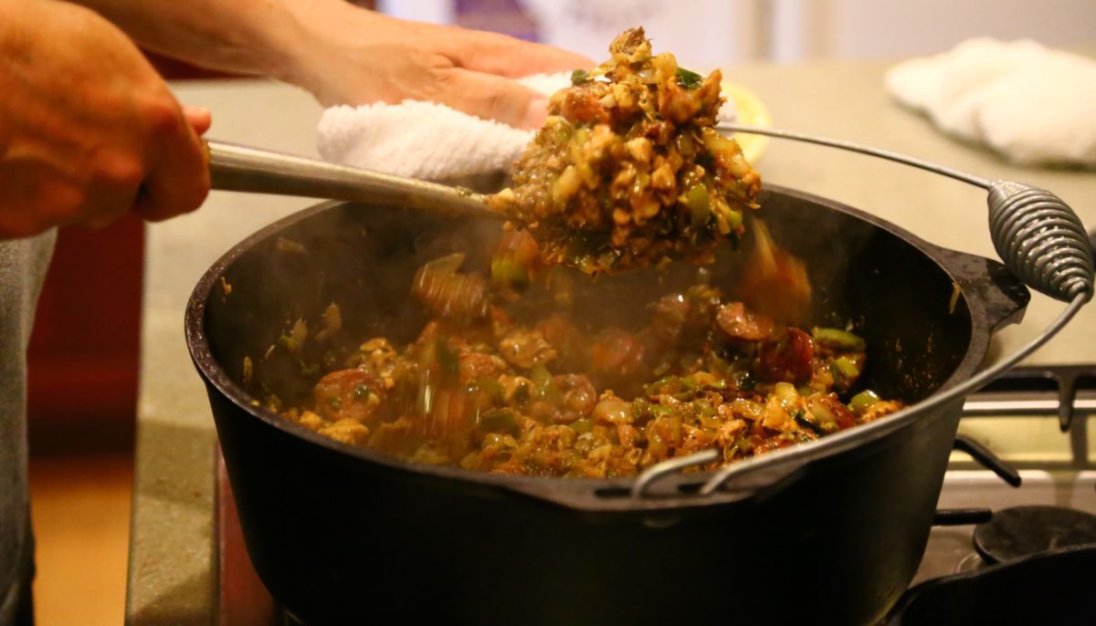 cajun jambalaya being stirred in a Dutch oven