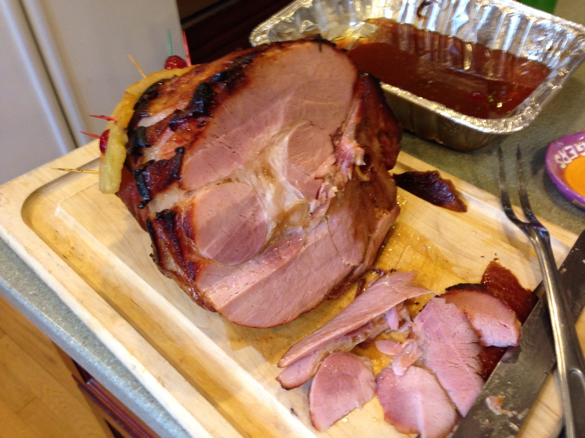 Baked ham sliced on a cutting board.