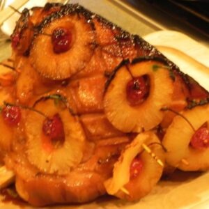 smoked ham with pineapple slices and cherry garnish