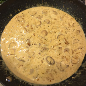 cream sauce with mushrooms in a saute pan