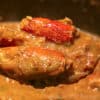 Spoonful of Cajun Crawfish Bisque with two stuffed heads