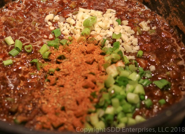 Add Creole Seasoning, garlic and green onions to Roux Mixture