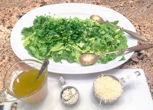 Sensation Salad ingredients on a white platter with salad tongs