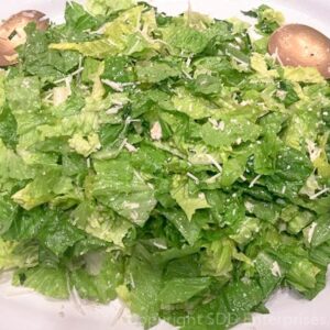 Sensation Salad on a white platter with salad tongs