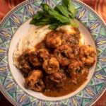 Shrimp and Grits in a green bowl with parsley