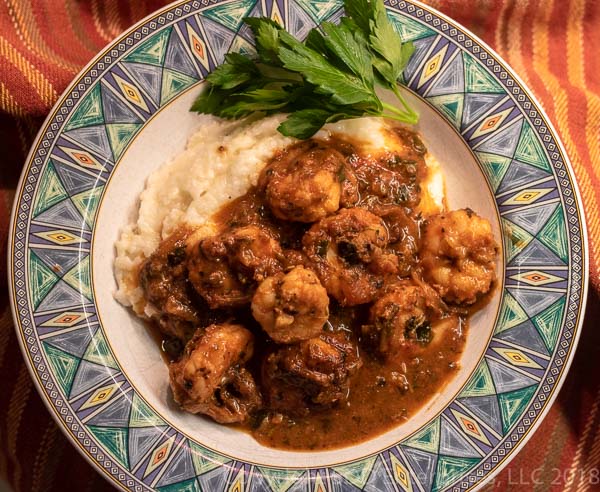 Shrimp and Grits in a green bowl with parsley