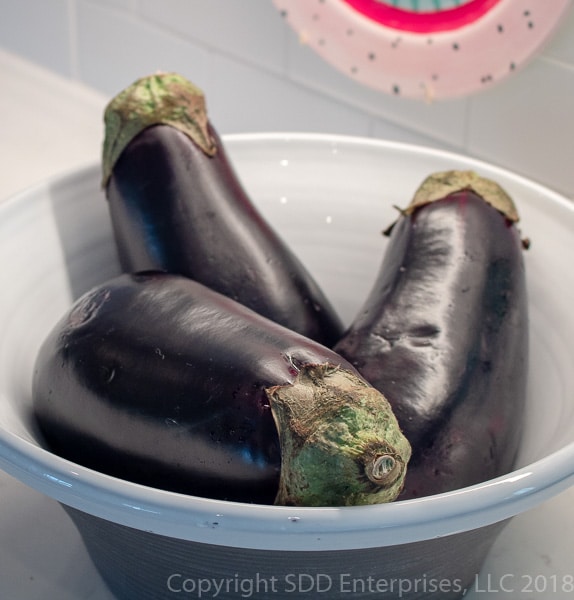 Three eggplant in a bowl