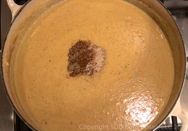 Adding spices to Mirliton Crab Bisque