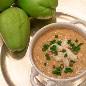 Mirliton Crab Bisque with crab meat in a bowl with three mirlitons