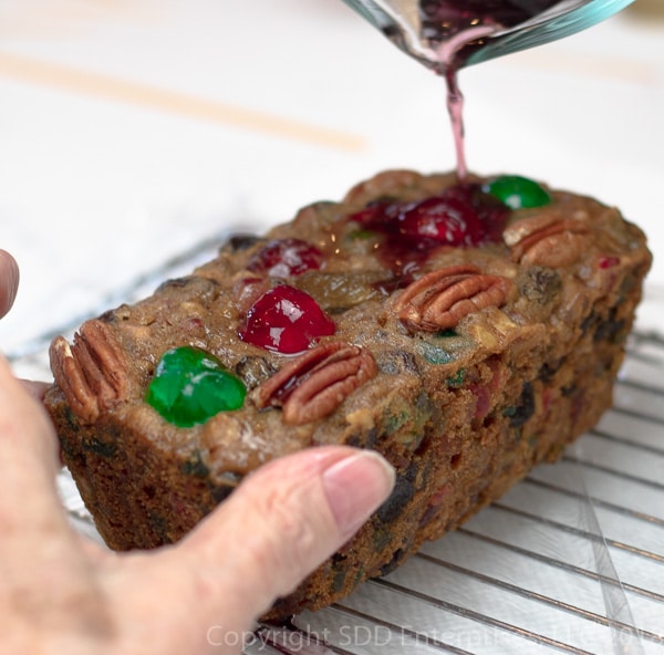 Pouring cherry brandy over fruit cake