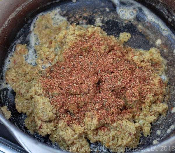 creole seasoning added to purred vegetables in a dutch oven