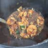 ladle of shrimp and okra gumbo over a stock pot