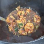 ladle of shrimp and okra gumbo over a stock pot