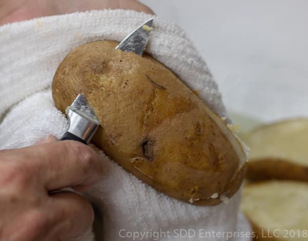 slicing the top off a russet potato