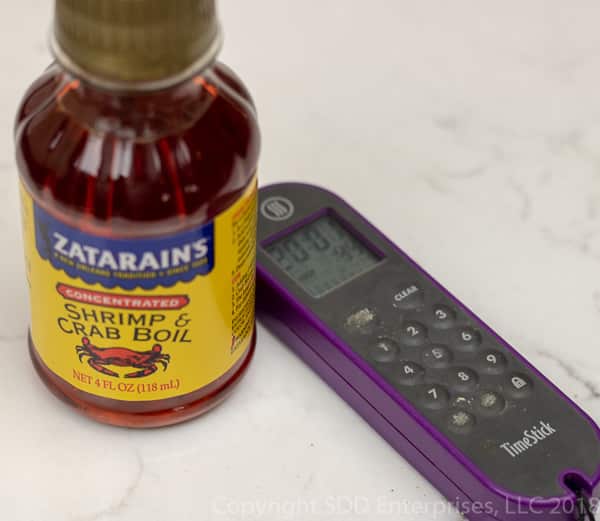 bottle of zatarain's crab boil and a timer