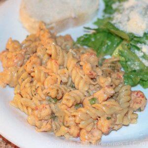 Crwafish Monica on a white plate with green salad and french bread