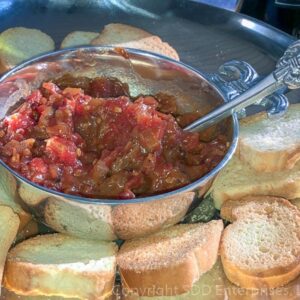 tomato bacon jam in a silver bowl on platter with bread