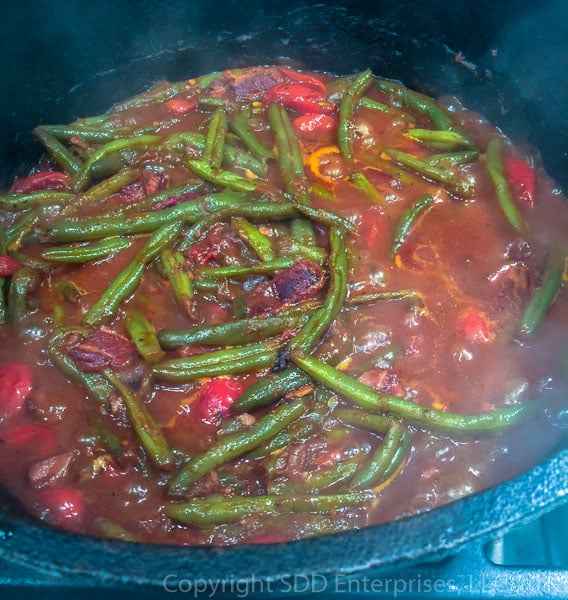 creole green beans smothering in cast iron dutch oven