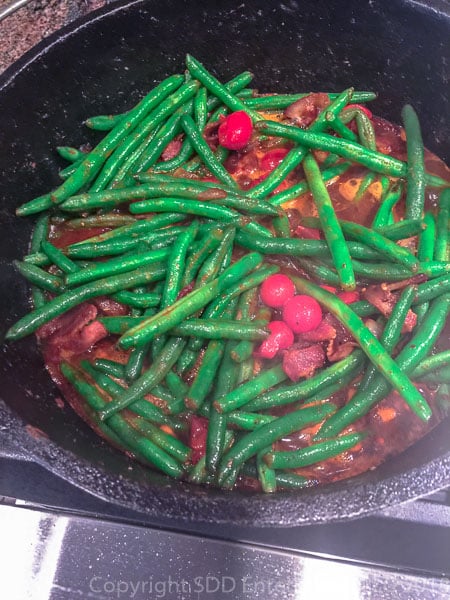 tomatoes added to the green beans in a dutch oven
