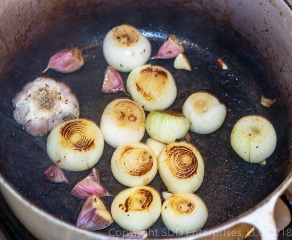 onions and garlic being sauteed in dutch oven