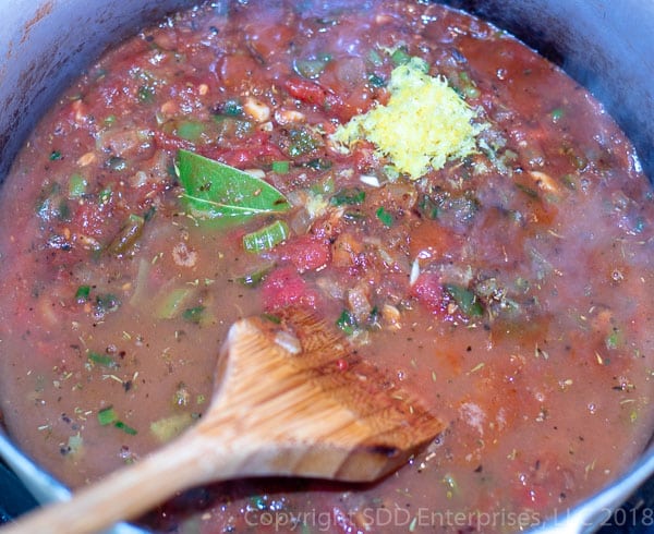 add the lemon zest and stock to simmering creole sauce