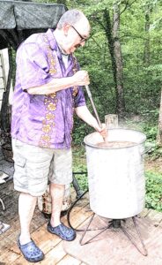 man stirring crawfish boil pot