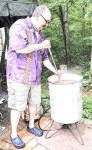 man stirring crawfish boil pot