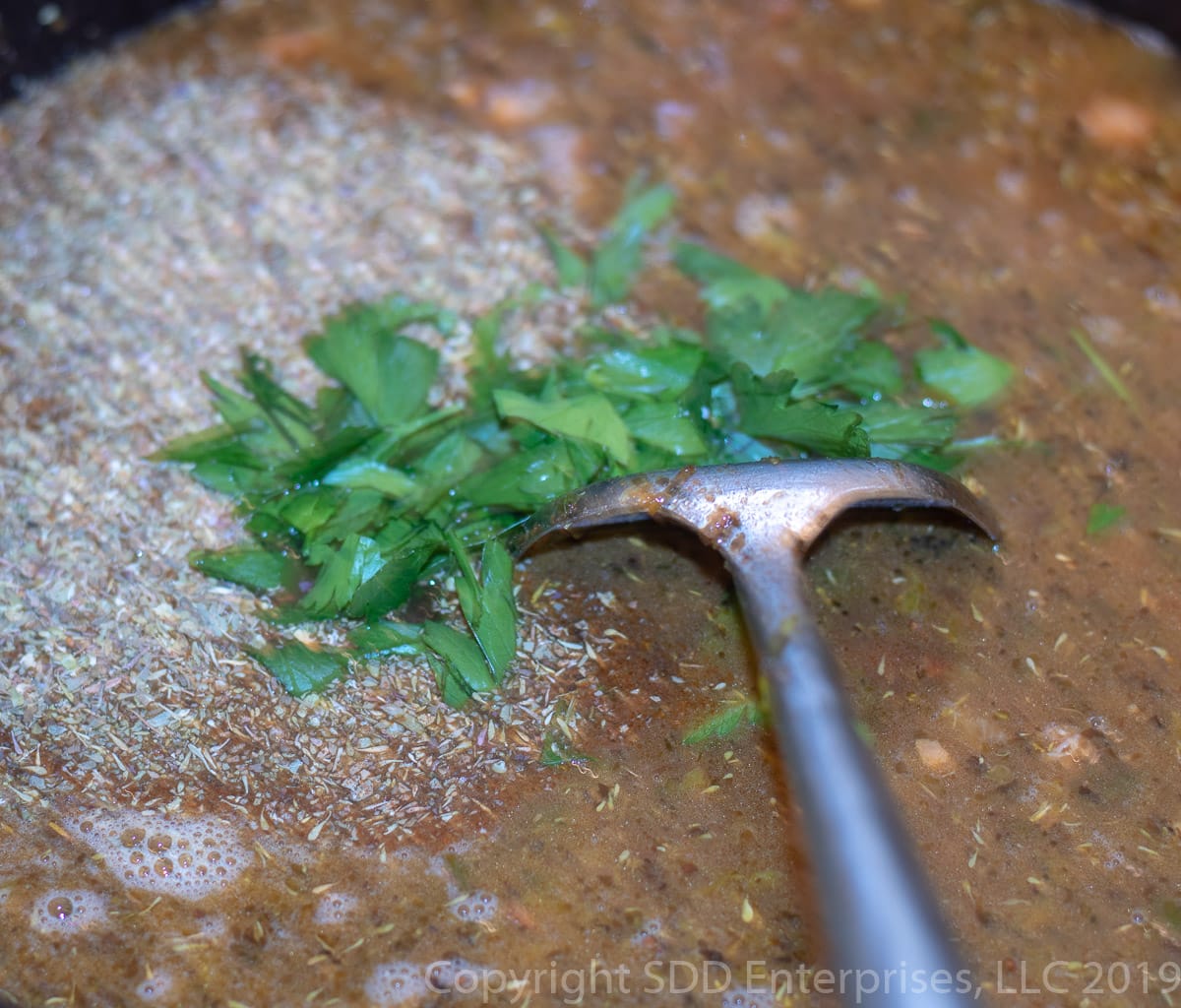 fresh parsley and herbs and spices added to stock for cajun jambalaya