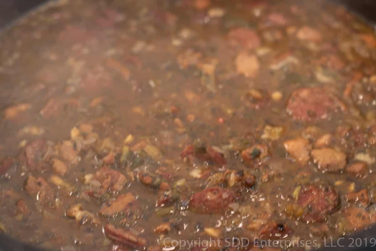 rice added to stock in a dutch oven for cajun jambalaya