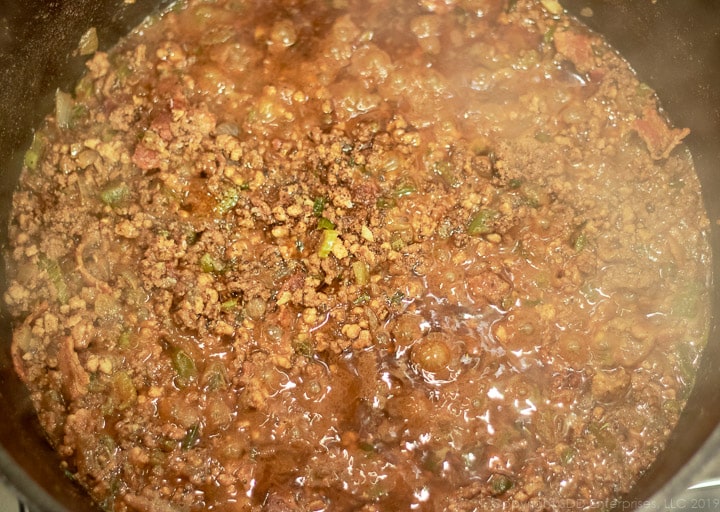 stock and worcestershire sauce added to meats in dutch oven for dirty rice
