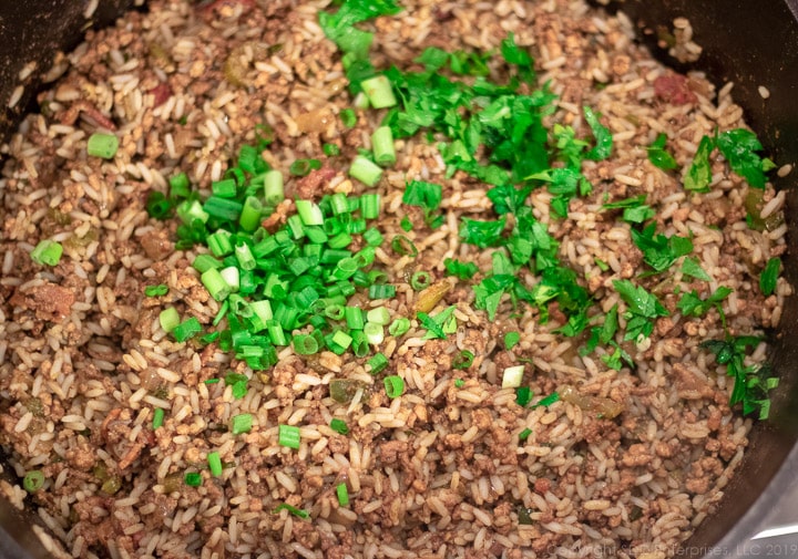chopped green onions added to the dirty rice in the dutch oven