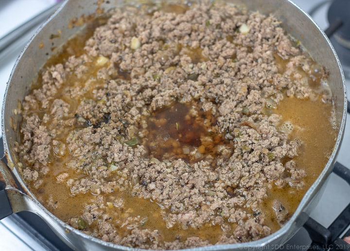 stock added to browned meat n a frying pan