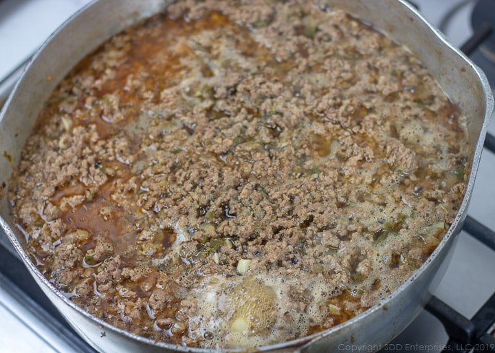 stock simmering in frying pan with browned meat
