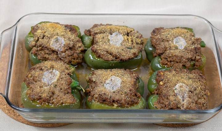 stuffed ell peppers in a baking dish right out of the oven