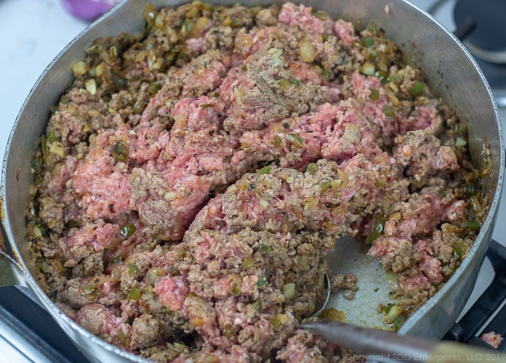 browning ground meat in a frying pan with onions and peppers