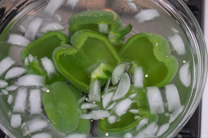 parboiled green bell peppers in an ice bath