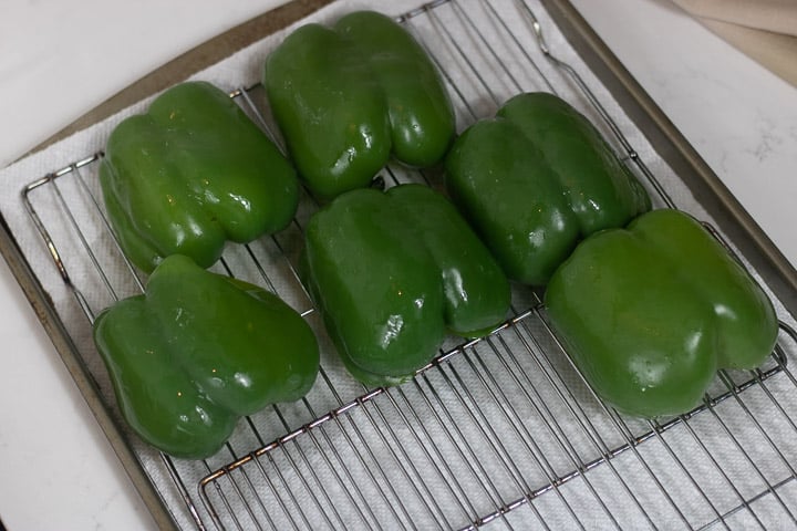 parboiled green bell peppers on a cooling rack