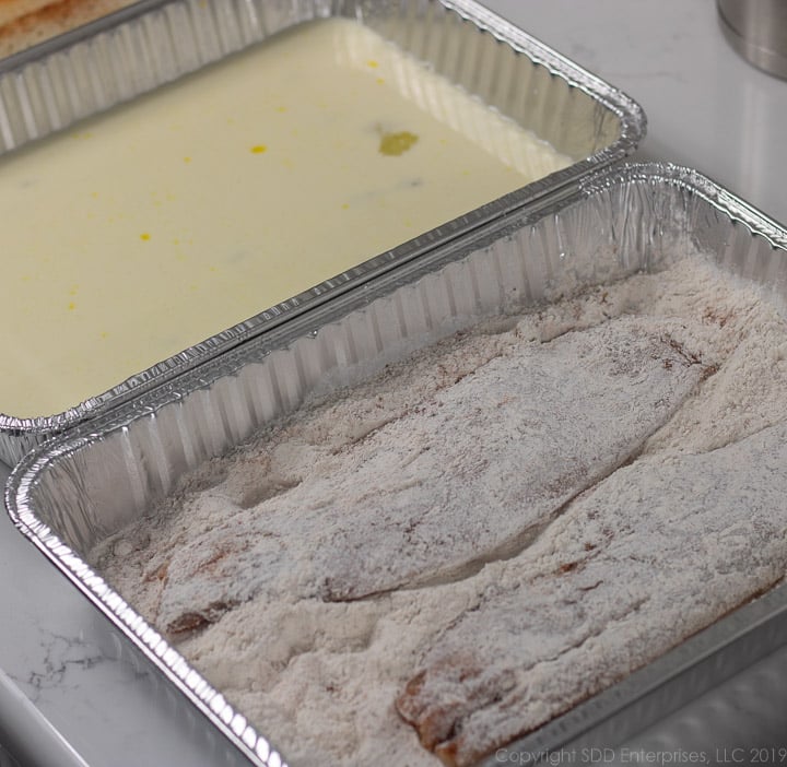 fish filets dredged in flour again after egg-milk dip