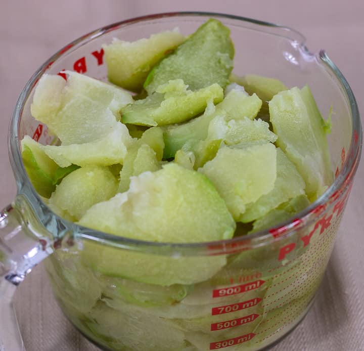 chopped and peeled mirlitons in a glass measuring cup