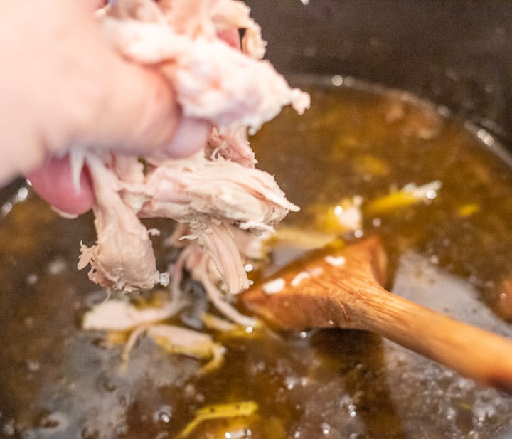 turkey pieces being added to turkey oyster gumbo in a stock pot