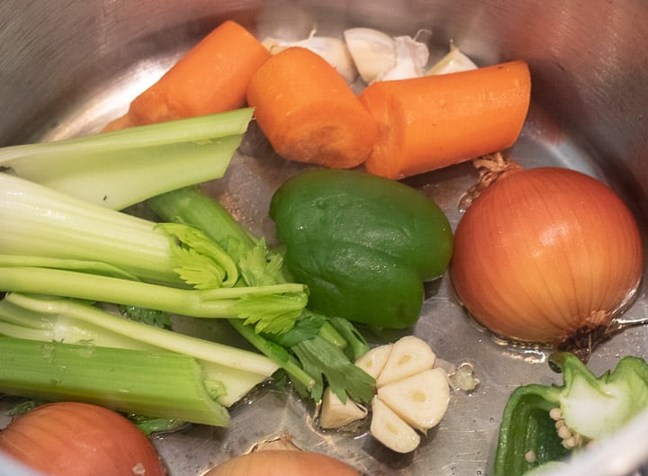 cut vegetables being browned in a stockpot for homemade turkey stock