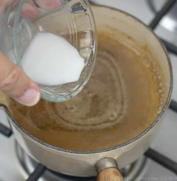 adding cornstarch paste to sauce pan with cane syrup rum sauce ingredients