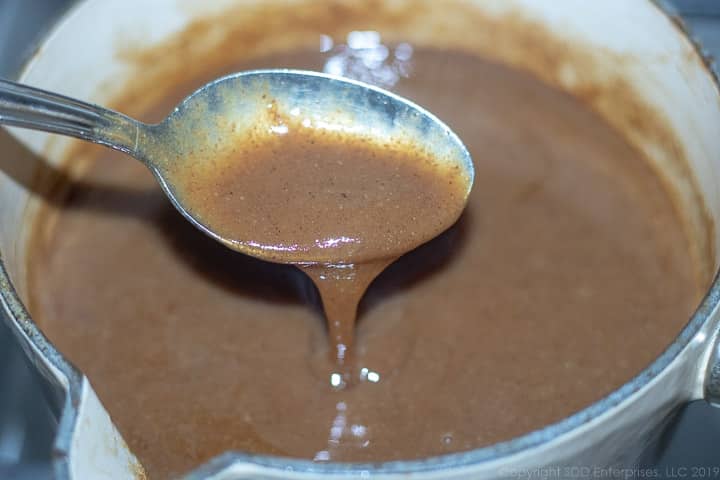 cane syrup rum sauce on a spoon in a sauce pan