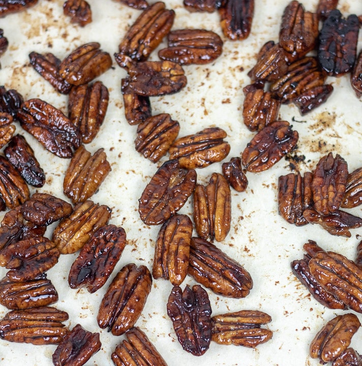 glazed pecans cooling on parchment paper