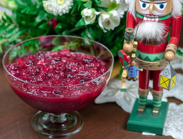 cranberry relish in a clear bowl with nutcracker and holiday greenery