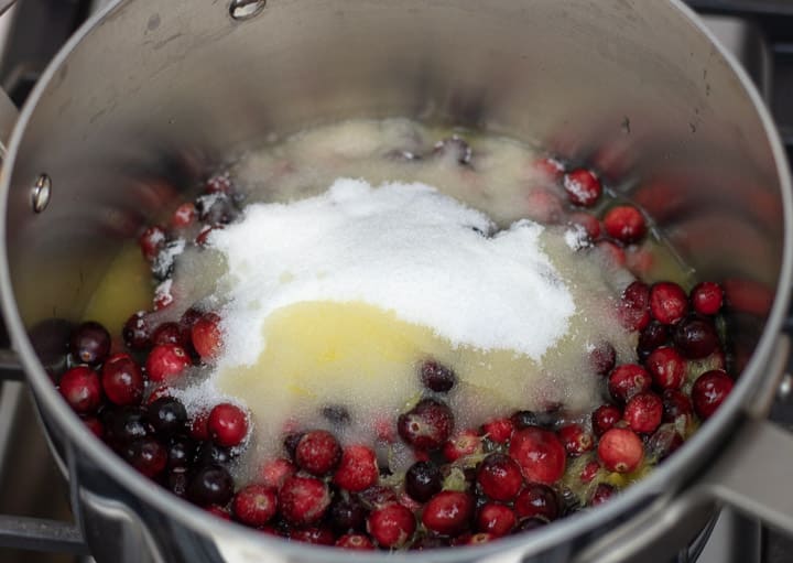 fresh cranberries with sugar and orange juice ina sauce pan for cranberry relish