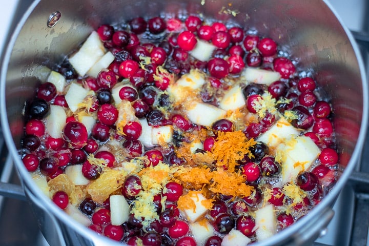 lemon and orange zest added to sauce pan with apples, oranges and cranberries for cranberry relish