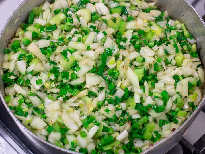 onions and celery frying in butter in a frying pan for oyster dressing