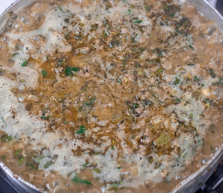 stock and dressing mix simmering in a frying pan for oyster dressing