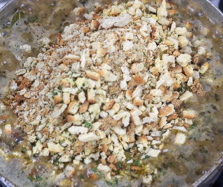 stale bread added to dressing mix in a frying pan for oyster dressing